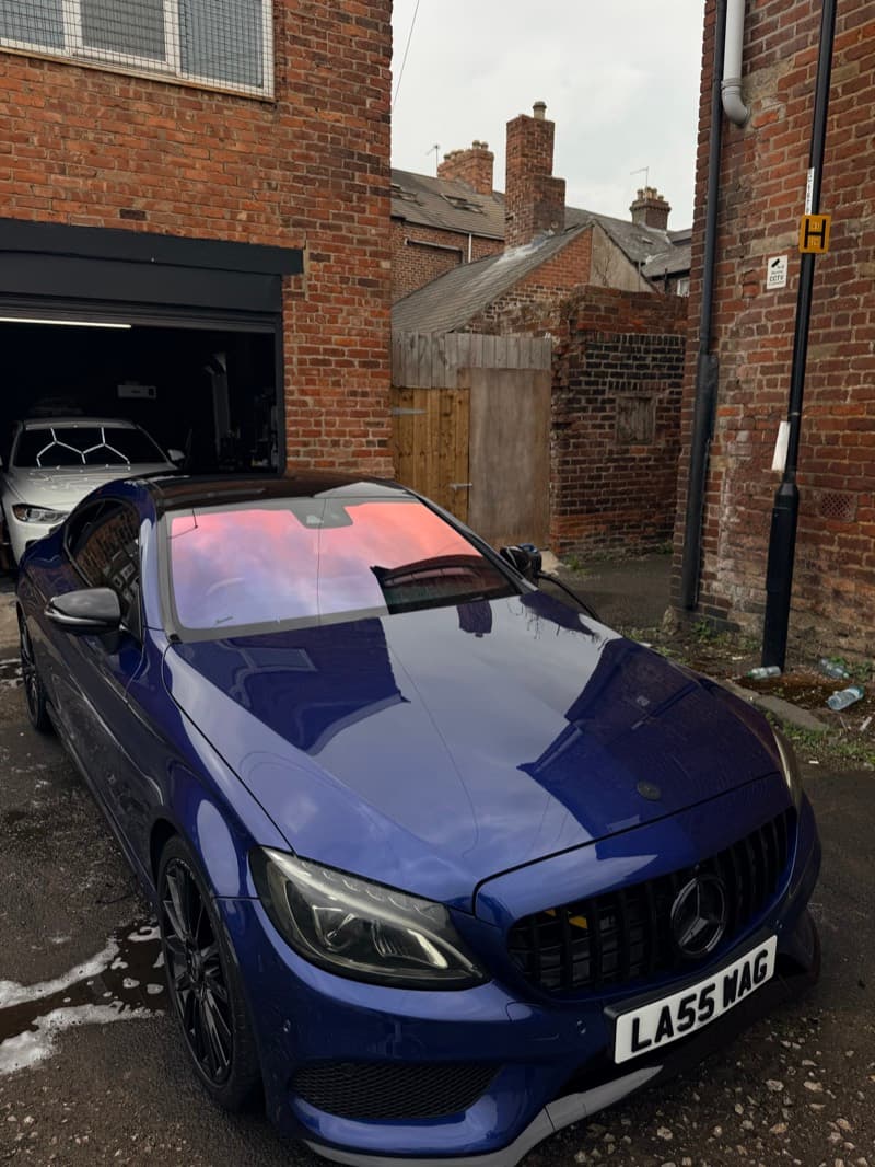 A VW Golf GTI covered in snow foam on the driveway before the wash