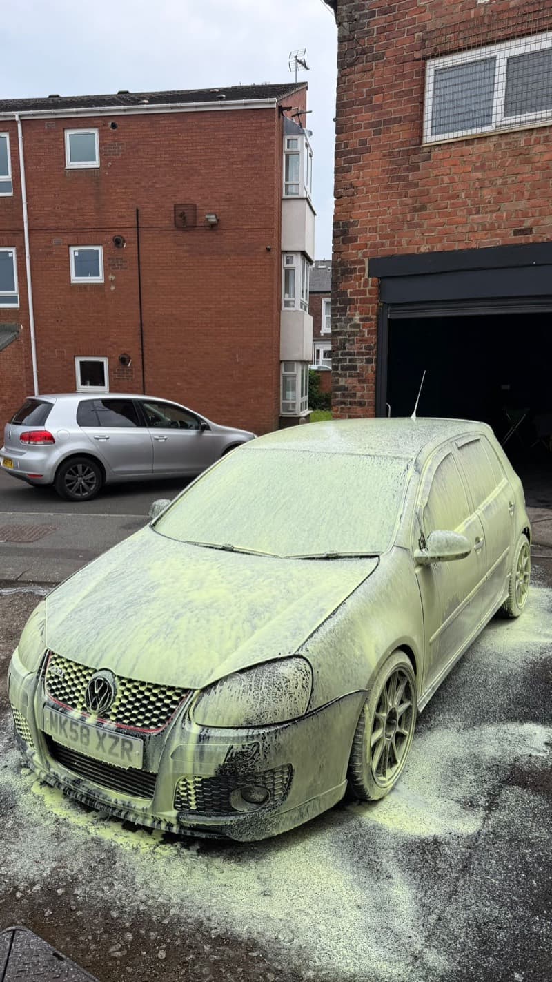 The same Golf GTI under snow foam, seen from the front wing