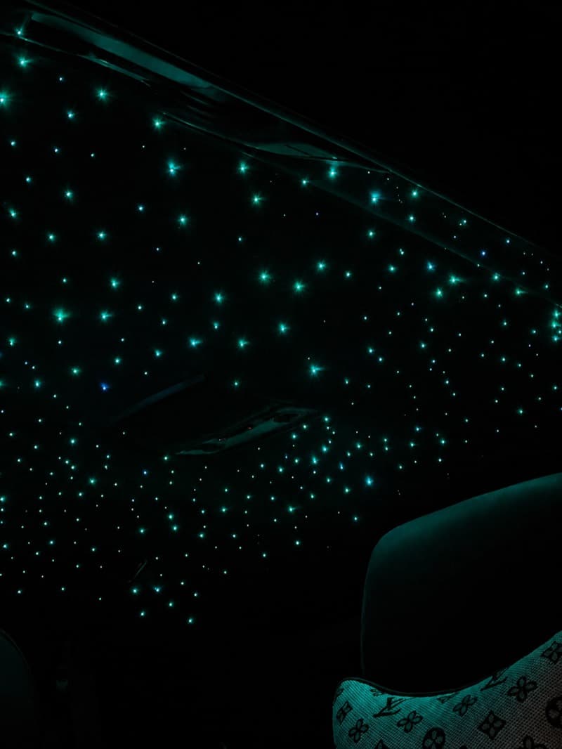 Teal starlight headliner spread across the roof above the rear seats
